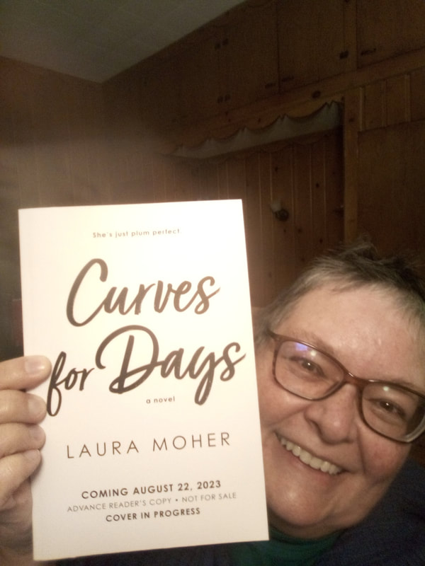 Image is a photo of a woman holding a book beside her face. The woman is white, fat, and smiling, with graying dark hair and dark glasses. The book is an Advance Reader's Copy of the novel Curves for Days by Laura Moher. The book jacket is described on the Books page of this author's website.Picture